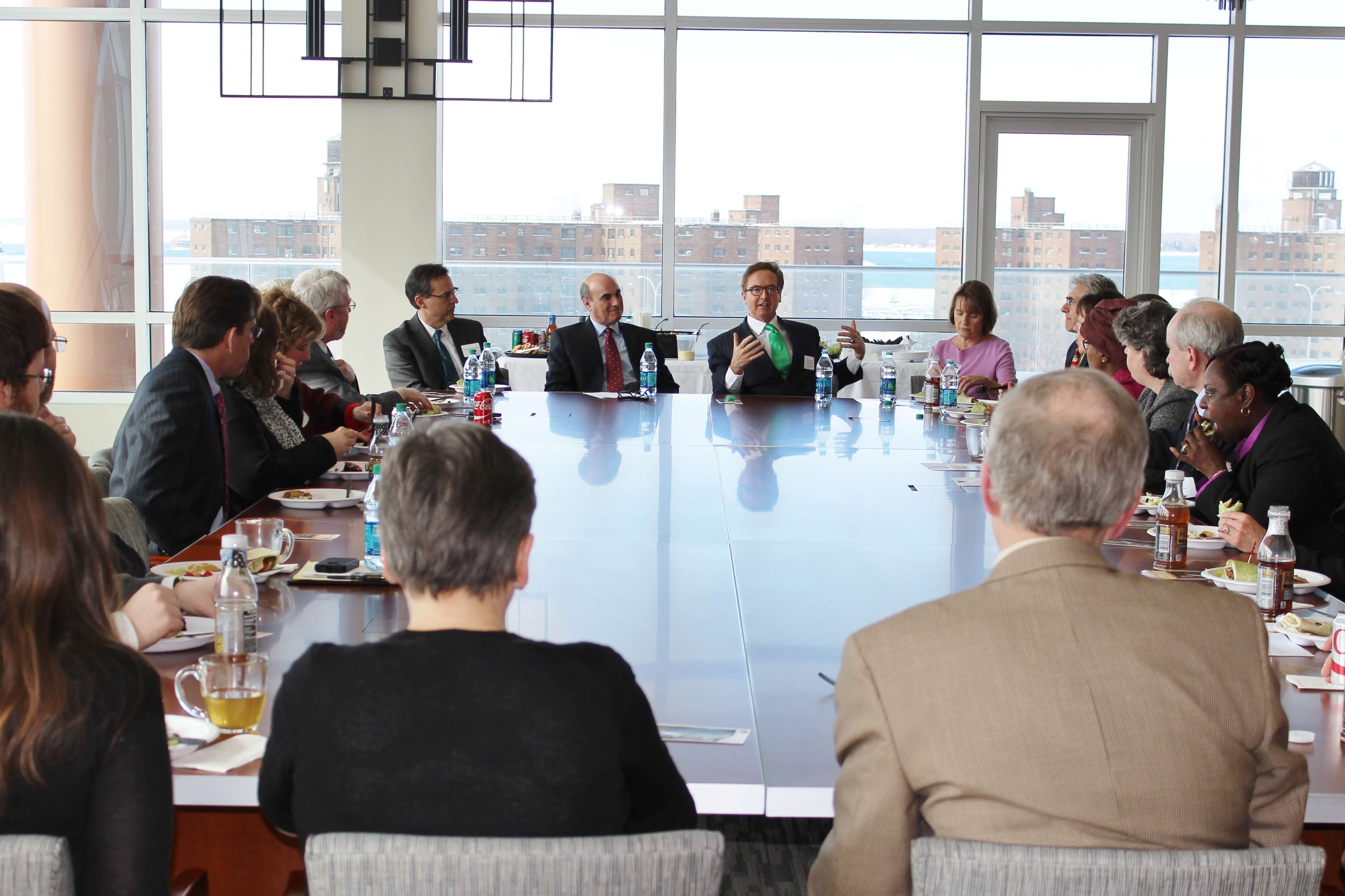 Diverse group of business people sitting around conference room table 