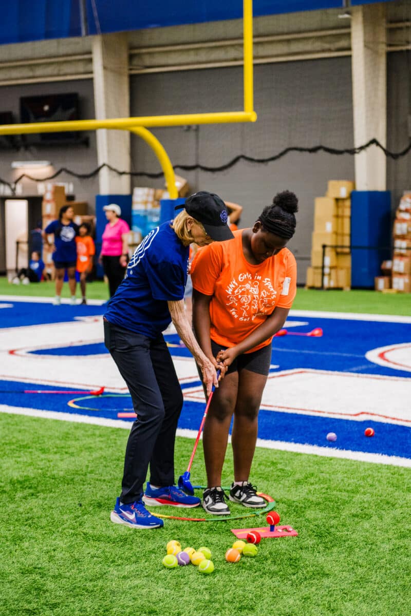 Mary Wilson teaching a girl to golf